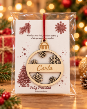 Bola de madera con el nombre Carla y copos de nieve, presentada en bolsa transparente con tarjeta.